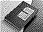 A small, black spiral-bound memo pad with squared grid paper, showing its front cover label featuring date markings and a barcode, resting on a wooden table.